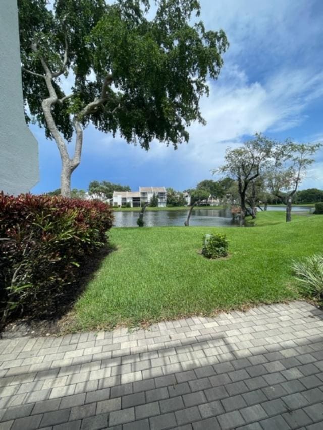 view of property's community with a water view and a yard