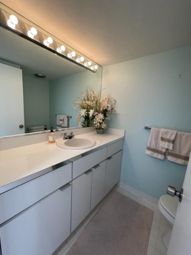 bathroom featuring toilet, tile floors, and vanity