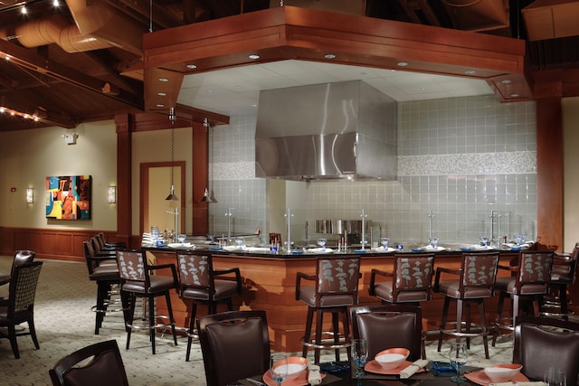 bar with light carpet, backsplash, and extractor fan