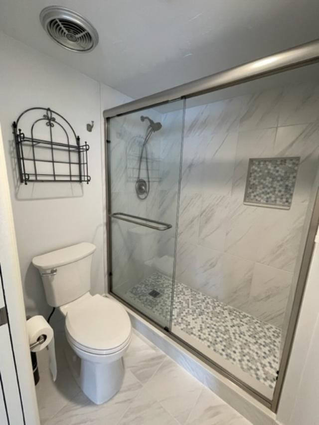 bathroom featuring walk in shower, tile flooring, and toilet