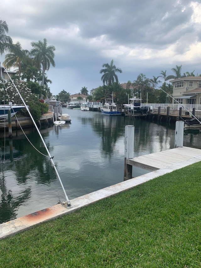 dock area with a yard and a water view