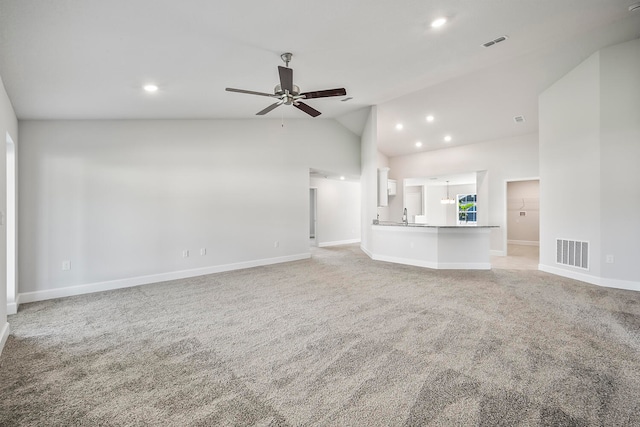 unfurnished living room with high vaulted ceiling, light colored carpet, ceiling fan, and sink