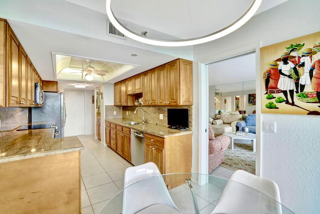 kitchen with sink, appliances with stainless steel finishes, a raised ceiling, light tile patterned floors, and ceiling fan