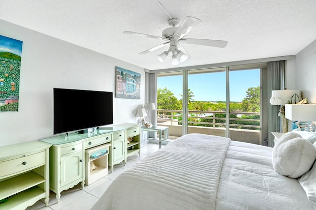 tiled bedroom with ceiling fan and a textured ceiling