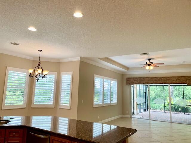 kitchen featuring ornamental molding, dishwasher, hanging light fixtures, and a textured ceiling