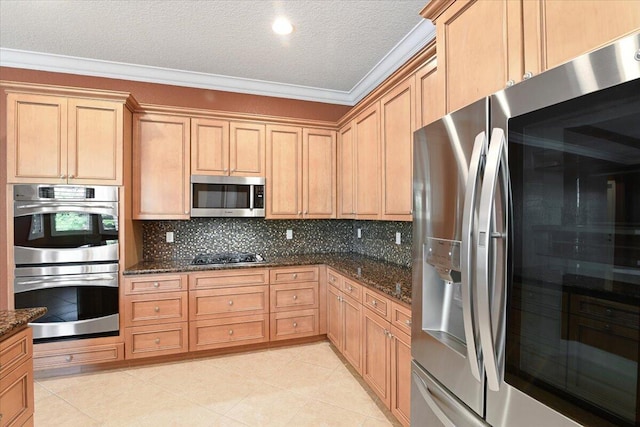 kitchen with stainless steel appliances, ornamental molding, backsplash, and dark stone counters