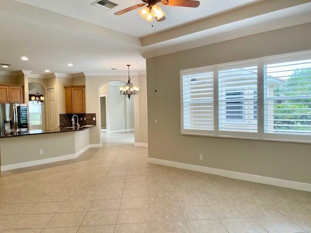 interior space with stainless steel refrigerator with ice dispenser, light tile patterned flooring, and crown molding