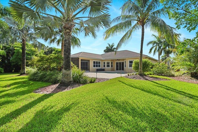 rear view of house with a yard and a patio