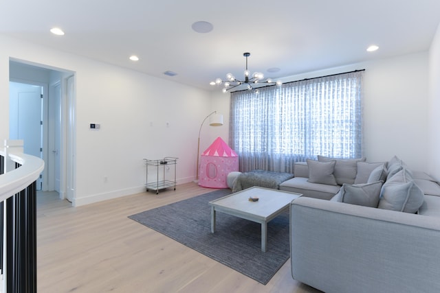 living room with light hardwood / wood-style flooring and a chandelier