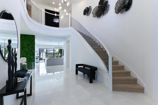 stairway featuring tile patterned flooring, a notable chandelier, and a high ceiling