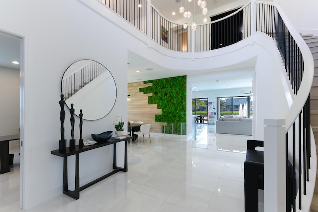 tiled foyer entrance featuring a high ceiling and an inviting chandelier