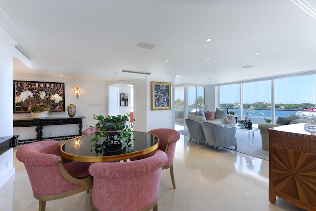 dining space featuring crown molding, a wall of windows, and a water view