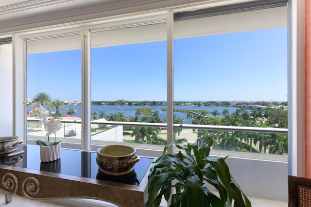 sunroom featuring a water view