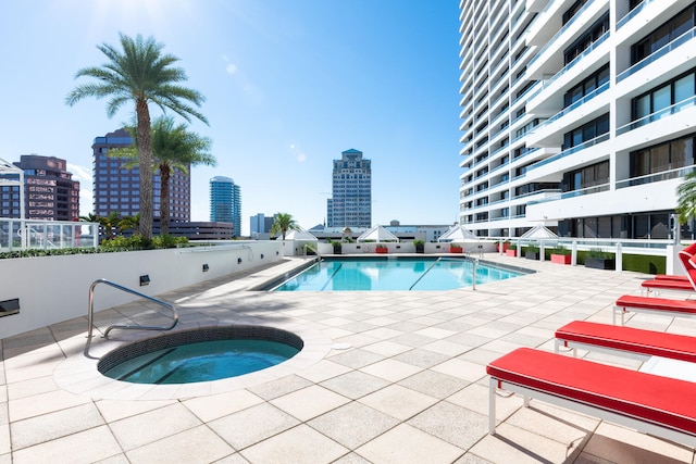 view of pool with a hot tub and a patio