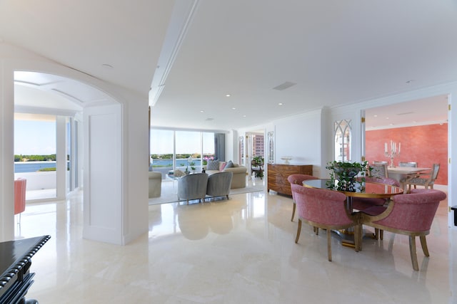 dining area featuring crown molding and a wall of windows