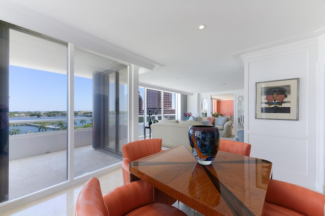 dining space with a wall of windows, ornamental molding, and a water view