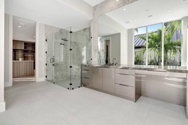 bathroom with vanity, a wall of windows, and a shower with shower door