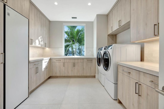 laundry area with cabinets, washing machine and dryer, and sink