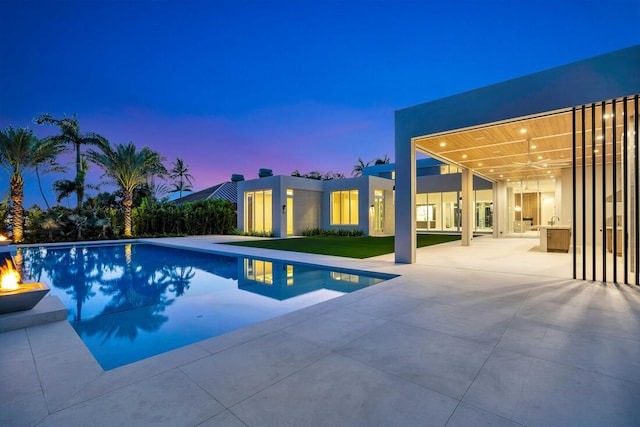 pool at dusk featuring a patio area