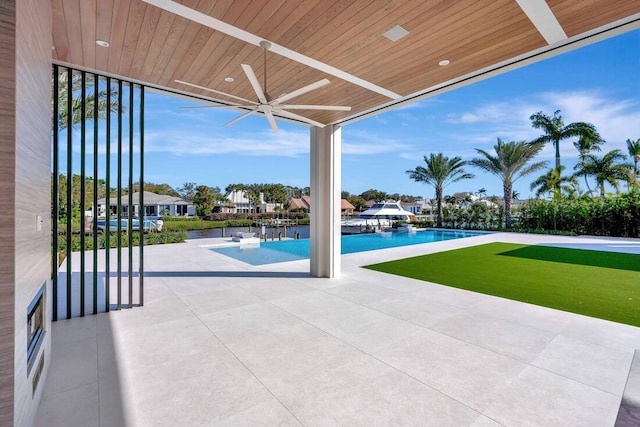 view of pool with a lawn, a patio area, and ceiling fan