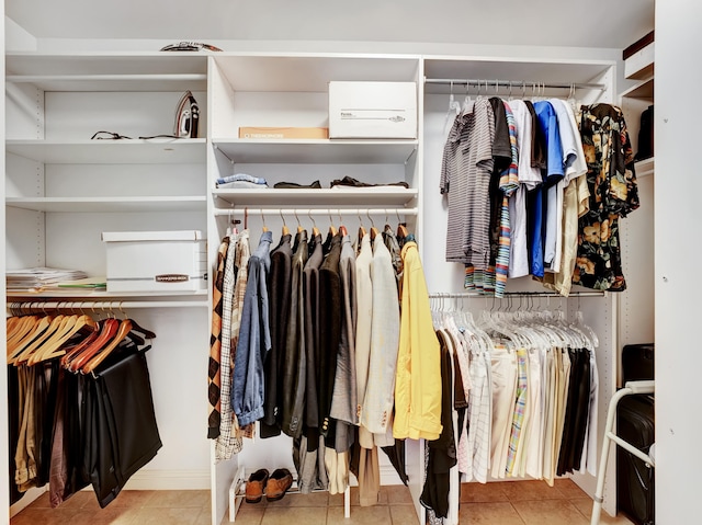 walk in closet with light tile floors