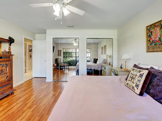 bedroom featuring two closets, ceiling fan, and light wood-type flooring