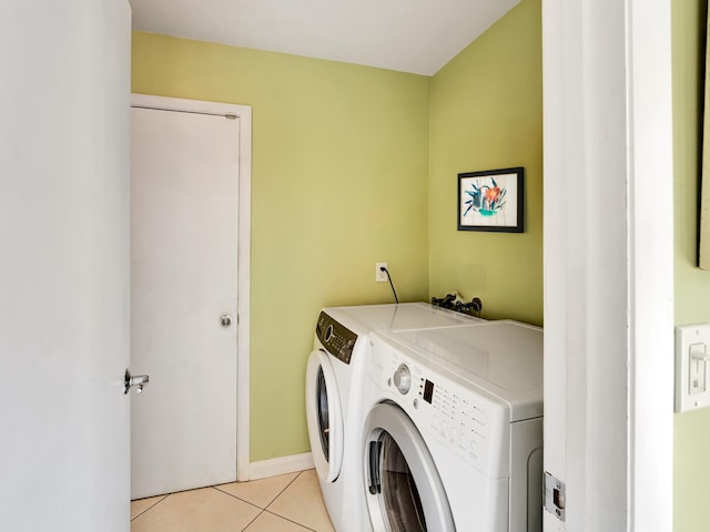 laundry area featuring washer and clothes dryer and light tile flooring