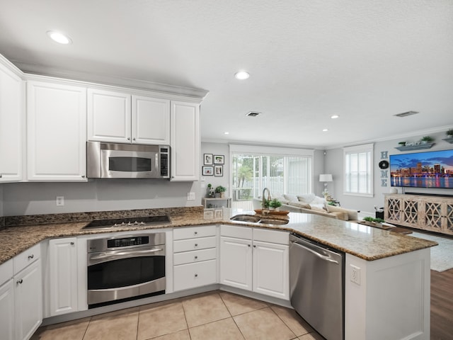 kitchen featuring white cabinetry, appliances with stainless steel finishes, sink, and ornamental molding