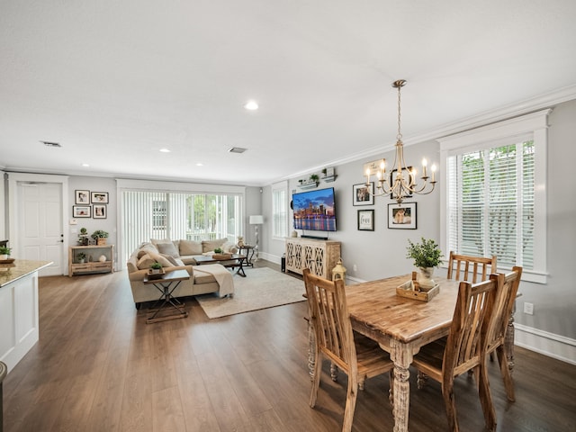 dining area with a notable chandelier, ornamental molding, dark wood-type flooring, and a wealth of natural light