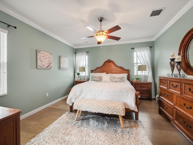 bedroom with ornamental molding, hardwood / wood-style floors, and ceiling fan