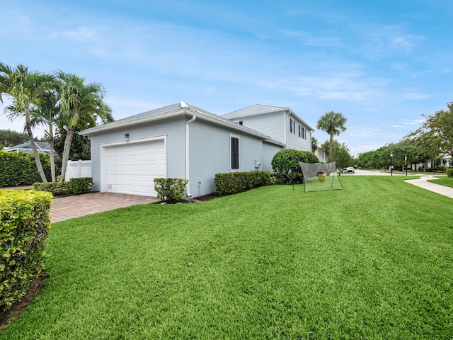 view of side of property with a lawn and a garage