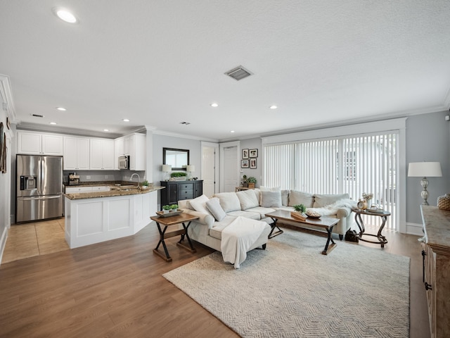 living room with crown molding and light wood-type flooring