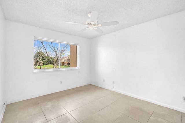 tiled spare room featuring a textured ceiling and ceiling fan