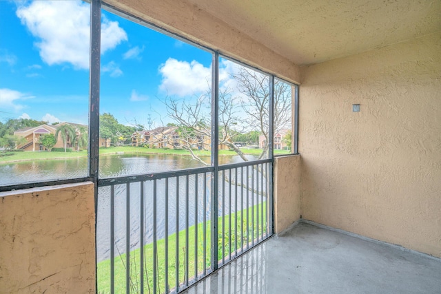 unfurnished sunroom featuring a water view