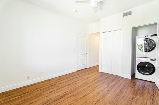 washroom with ceiling fan, hardwood / wood-style flooring, and stacked washer and dryer