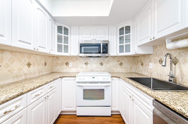 kitchen featuring white cabinets, backsplash, dark wood-type flooring, sink, and stainless steel appliances