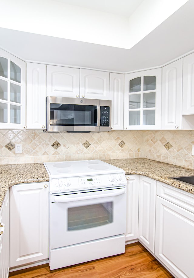 kitchen with backsplash, white electric range, white cabinets, and light hardwood / wood-style floors