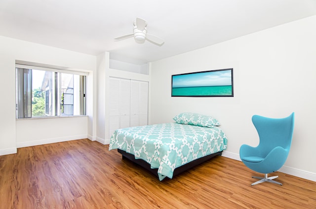 bedroom with a closet, hardwood / wood-style floors, and ceiling fan