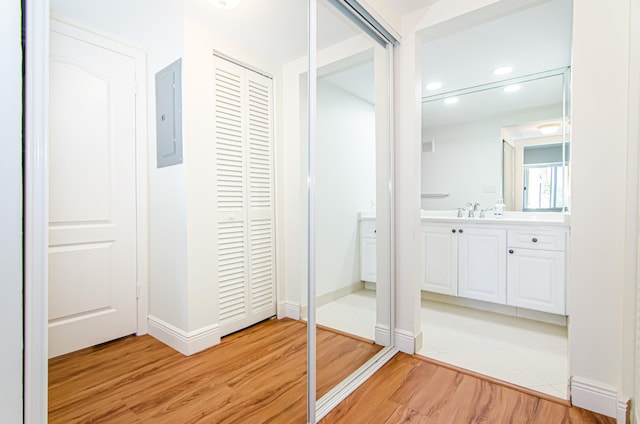 interior space featuring vanity, electric panel, and hardwood / wood-style flooring