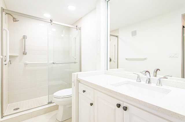 bathroom with vanity, tile patterned floors, toilet, and an enclosed shower