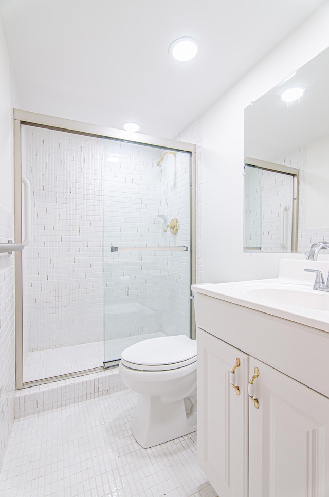 bathroom featuring vanity, tile patterned flooring, toilet, and an enclosed shower