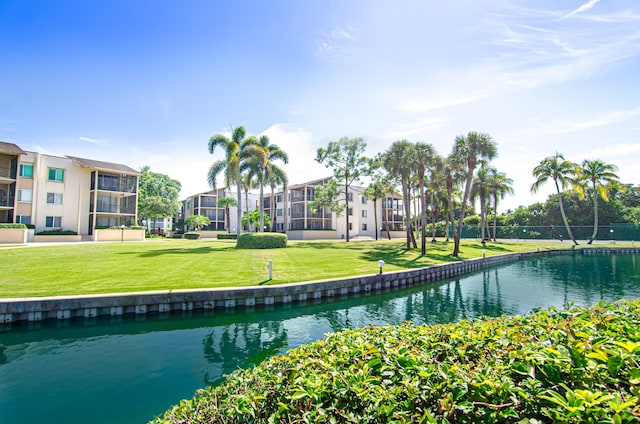 view of community featuring a yard and a water view