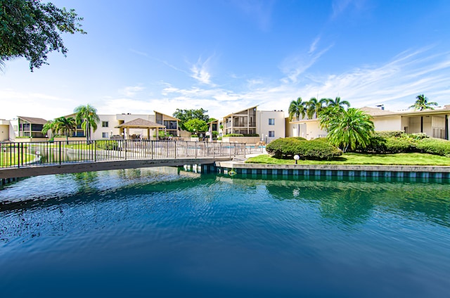 view of pool with a water view and a lawn