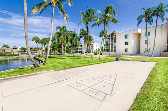 surrounding community featuring a water view and a lawn