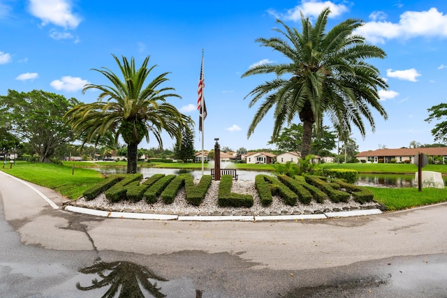 view of property's community with a water view and a yard