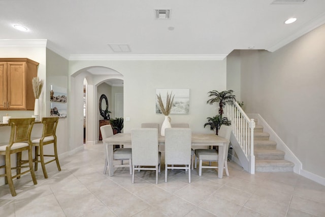 dining space with light tile flooring and ornamental molding