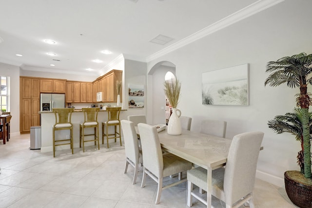 dining space featuring light tile flooring and crown molding