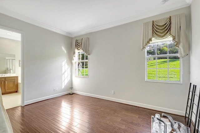 spare room with plenty of natural light, crown molding, and dark wood-type flooring