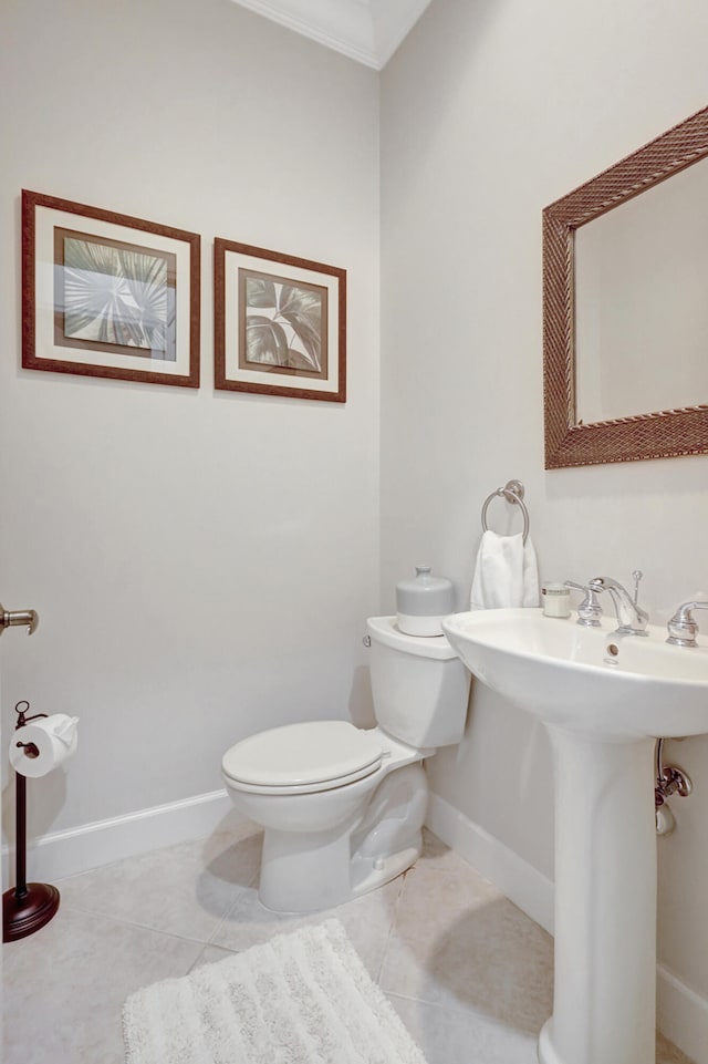 bathroom featuring toilet, ornamental molding, and tile flooring