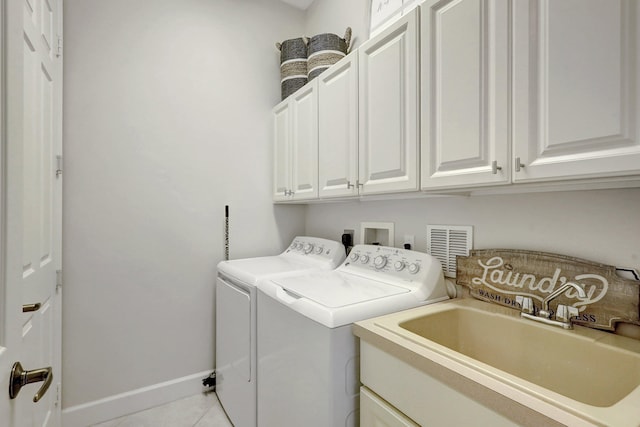 laundry area with light tile flooring, cabinets, hookup for an electric dryer, sink, and washing machine and clothes dryer